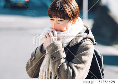 コートとマフラーとマスクを着用した冬の女性 コートとマフラーとマスクを着用した冬の女性 74384429