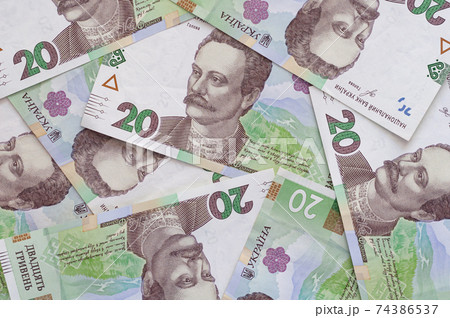 Paper money, Ukrainian hryvnia in denomination 20 hryvnia, new money, background with scattered banknotes. Paper money, Ukrainian hryvnia in denomination 20 hryvnia, new money, background with scattered banknotes. 74386537