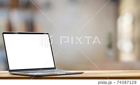 Computer laptop with white blank screen putting on the modern working table with blurred comfortable office as background. Void screen for advertise concept. Computer laptop with white blank screen putting on the modern working table with blurred comfortable office as background. Void screen for advertise concept. 74387129