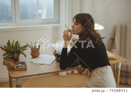 Woman Writer Working on a Typewriter Indoors Woman Writer Working on a Typewriter Indoors 74388451