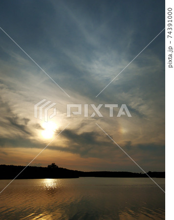 Natural landscape. Sunset over water, reflection of the sun and clouds in the water 74391000