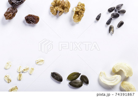 Seeds of sunflower, nuts, fruits and dried fruits on white background with copy space. Seeds of sunflower, nuts, fruits and dried fruits on white background with copy space. 74391867