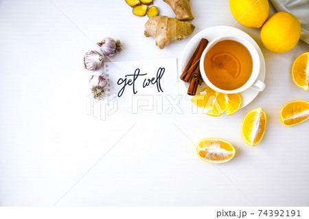 GET WELL - written on piece of paper among the products for the treatment of common cold - lemon, ginger, chamomile tea. Vitamin natural drink GET WELL - written on piece of paper among the products for the treatment of common cold - lemon, ginger, chamomile tea. Vitamin natural drink 74392191