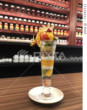 オシャレな空間に映えるフルーツいっぱいのパフェの写真素材