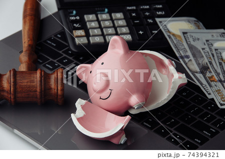 Broken piggy bank, money and wooden gavel on keyboard close-up. Auction and bankruptcy concept Broken piggy bank, money and wooden gavel on keyboard close-up. Auction and bankruptcy concept 74394321