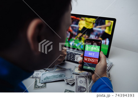 Man watching football match online broadcast on his laptop and celebrate after winning result Man watching football match online broadcast on his laptop and celebrate after winning result 74394393