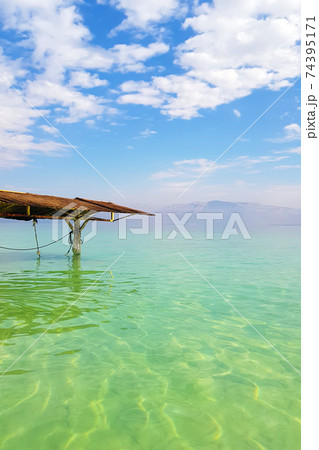 Dead sea, mountains and sun canopy on sunny day. Vertical photography. Dead sea, mountains and sun canopy on sunny day. Vertical photography. 74395171