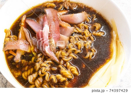Egg noodles in a white plate and meat 74397429
