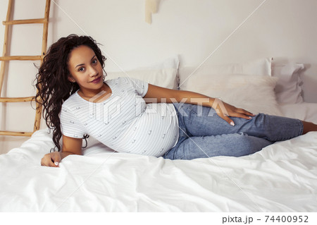 young pretty african american woman pregnant laying in bed, lifestyle people concept 74400952