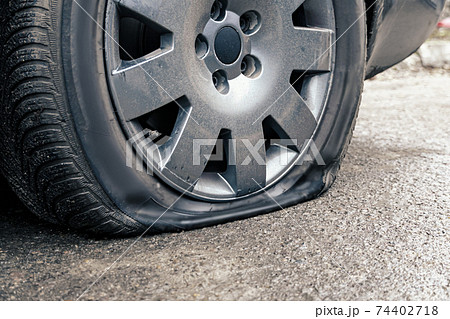 flat car tire close up, punctured wheel 74402718