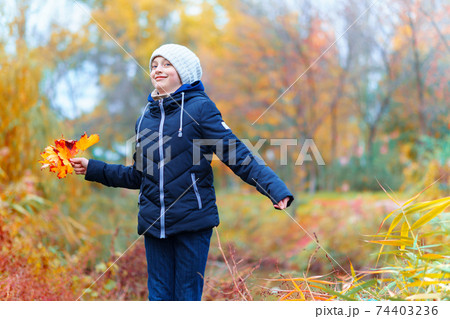 a girl posing near river and enjoys autumn, beautiful nature with yellow leaves 74403236