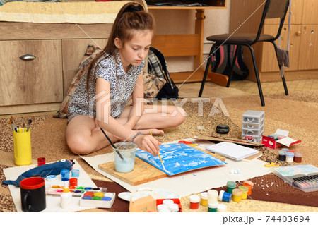 girl draws at home, artistic creation, makes creative artwork from paper, paints and brushes girl draws at home, artistic creation, makes creative artwork from paper, paints and brushes 74403694