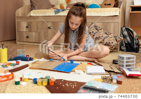 girl draws at home, artistic creation, makes creative artwork from paper, paints and brushes girl draws at home, artistic creation, makes creative artwork from paper, paints and brushes 74403730