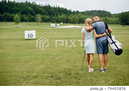 Beautiful couple playing golf on a golf course 74403856