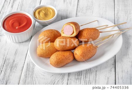 Corn dogs on white serving plate Corn dogs on white serving plate 74405336