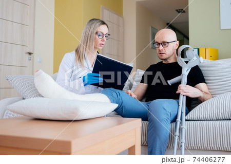 A female doctor visits the sick patient and explains the course of the disease to him. 74406277