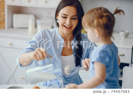 Cute family prepare the breakfest in a kitchen Cute family prepare the breakfest in a kitchen 74407083