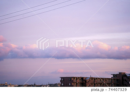 夕焼けを予感させるピンクがかった雲が浮かぶ午後の空の写真素材
