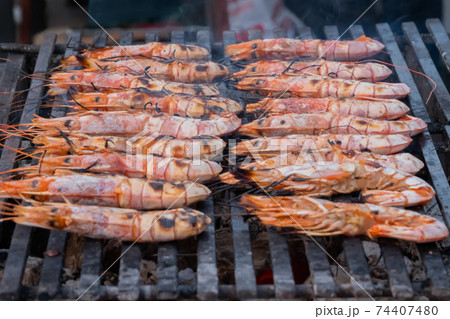 Process of cooking fresh red langoustine shrimps, prawns on grill - street food 74407480
