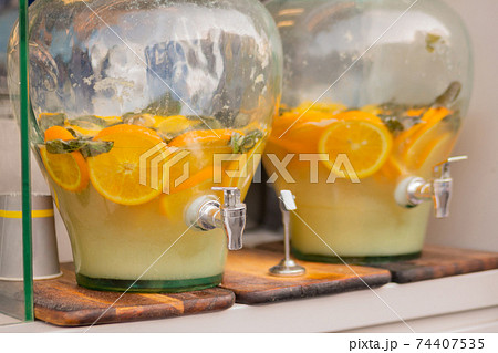 Vintage pitcher of homemade lemonade, mojito with mint and orange slices Vintage pitcher of homemade lemonade, mojito with mint and orange slices 74407535