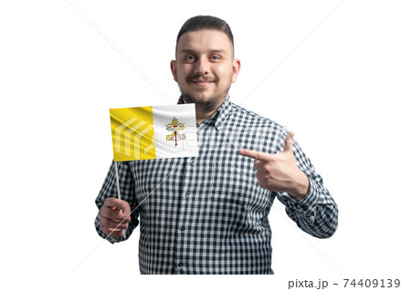White guy holding a flag of Vatican and points the finger of the other hand at the flag isolated on a white background 74409139