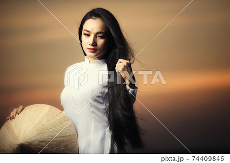 Portrait of Beautiful Asian girls with Ao Dai vietnam traditional dress on Sunset landscapes 74409846
