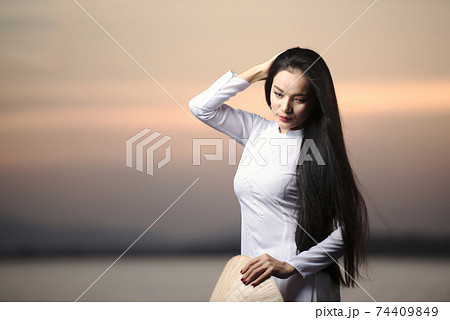 Portrait of Beautiful Asian girls with Ao Dai vietnam traditional dress on Sunset landscapes 74409849