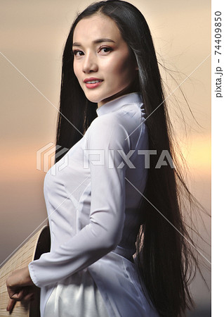 Portrait of Beautiful Asian girls with Ao Dai vietnam traditional dress on Sunset landscapes 74409850