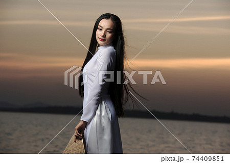 Portrait of Beautiful Asian girls with Ao Dai vietnam traditional dress on Sunset landscapes 74409851