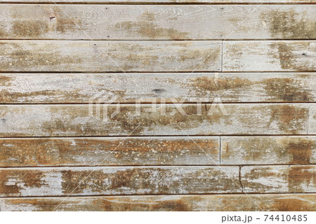 Old wooden wall where the paint has peeled off And slightly moldy 74410485