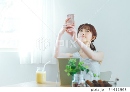 お家でスマホを使って自撮りする若い女性 お家でスマホを使って自撮りする若い女性 74411963