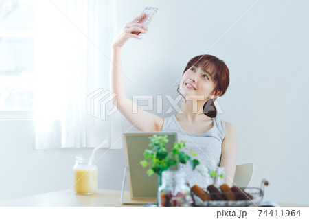 お家でスマホを使って自撮りする若い女性 お家でスマホを使って自撮りする若い女性 74411964