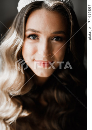 Gorgeous bride in robe posing and preparing for the wedding ceremony face in a room 74416897