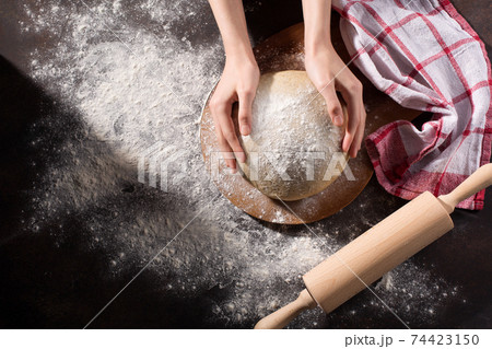 Homemade wholemeal dough for bread and female hands on wooden table with flour, rolling-pin, dark rustic background. Homemade wholemeal dough for bread and female hands on wooden table with flour, rolling-pin, dark rustic background. 74423150