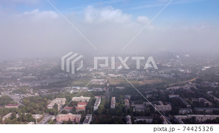 Smog over the city. Aerial view of smog. Cities and industrial smoke clouds the sky. Air pollution Smog over the city. Aerial view of smog. Cities and industrial smoke clouds the sky. Air pollution 74425326