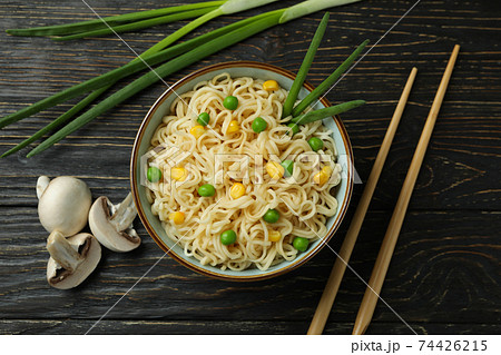 Plate with noodles, ingredients and chopsticks on wooden background Plate with noodles, ingredients and chopsticks on wooden background 74426215