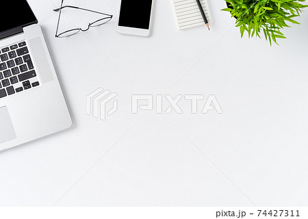 Overhead shot of laptop and business accessories on white background with copyspace. Office desktop.  Flat lay 74427311