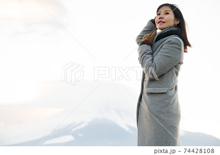 夕暮れの富士山をバックにポーズを取る女性 74428108