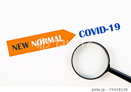 Time for a new normal with magnigying glass on paper. 74428136