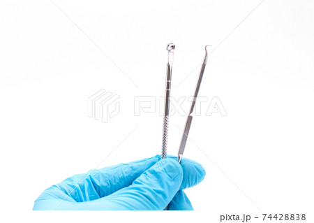 Hand in a blue glove holds Acne removal tools. Cosmetic tool. Hand in a blue glove holds Acne removal tools. Cosmetic tool. 74428838