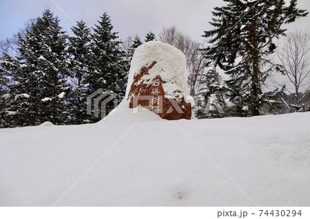 雪に埋もれた石勝樹海ロードの石碑の写真素材