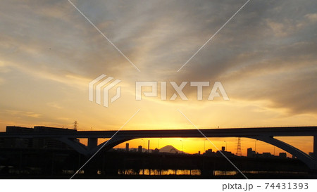 足立区と荒川区を繋ぐ扇大橋を渡る舎人線と富士山と荒川遊園地の観覧車の観える冬の夕暮れの風景 足立区と荒川区を繋ぐ扇大橋を渡る舎人線と富士山と荒川遊園地の観覧車の観える冬の夕暮れの風景 74431393