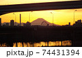足立区と荒川区を繋ぐ扇大橋を渡る舎人線と富士山と荒川遊園地の観覧車の観える冬の夕暮れの風景　 74431394