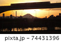 足立区と荒川区を繋ぐ扇大橋を渡る舎人線と富士山と荒川遊園地の観覧車の観える冬の夕暮れの風景　 74431396