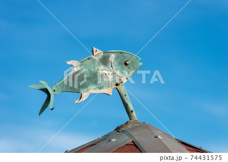 Closeup of a Fish Made of Green Copper on Top of a Roof Closeup of a Fish Made of Green Copper on Top of a Roof 74431575