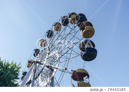 Beautiful retro colorful ferris wheel of the amusement park in the blue sky background.. 74433165