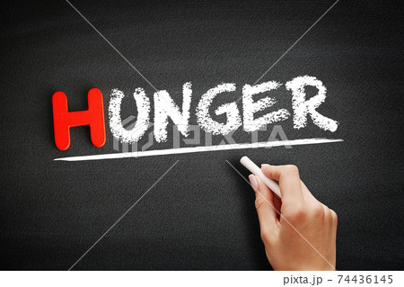 Hand writing hunger on blackboard, concept background 74436145