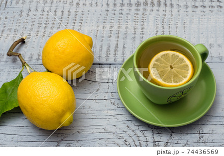 Lemons and cup of tea on saucer 74436569