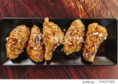 Close up of homemade crispy Korean fried chicken served on a long dish. Close up of homemade crispy Korean fried chicken served on a long dish. 74437483