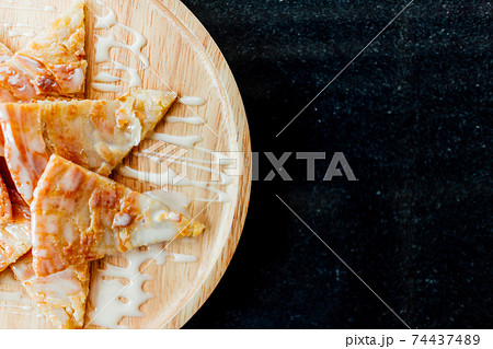 Roti with condensed milk dessert served on wooden dish. Roti with condensed milk dessert served on wooden dish. 74437489